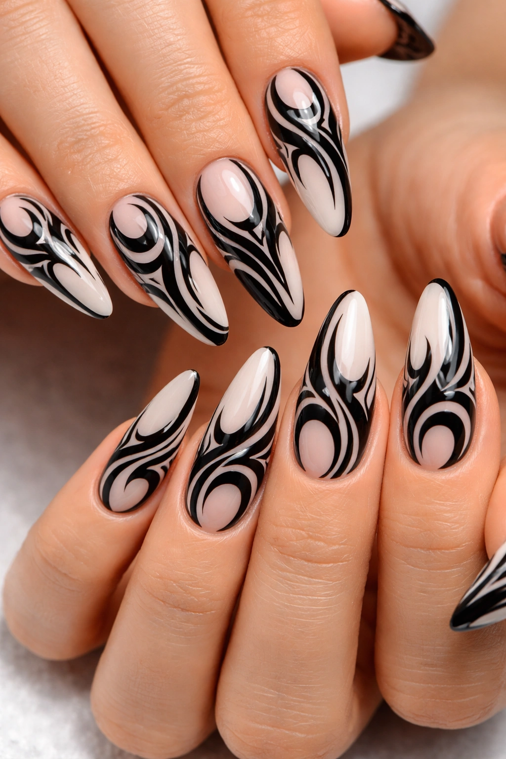 Nails with bold black tribal swirl patterns on a light base