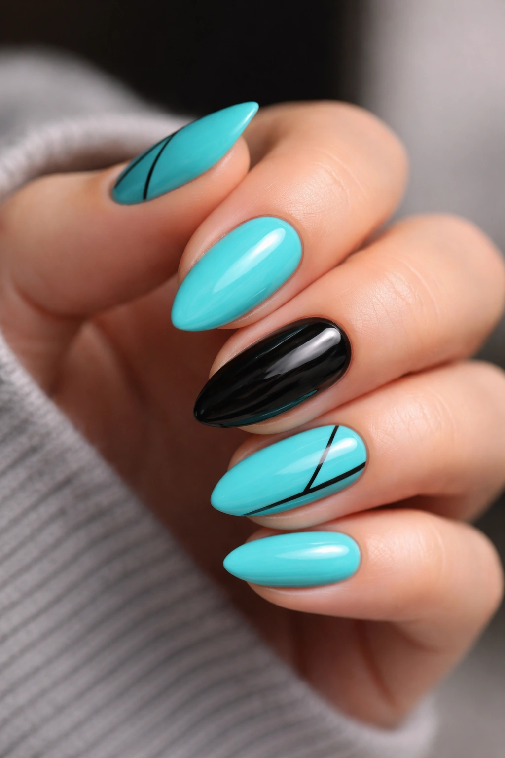Turquoise and black nails with a single black accent on short almond nails