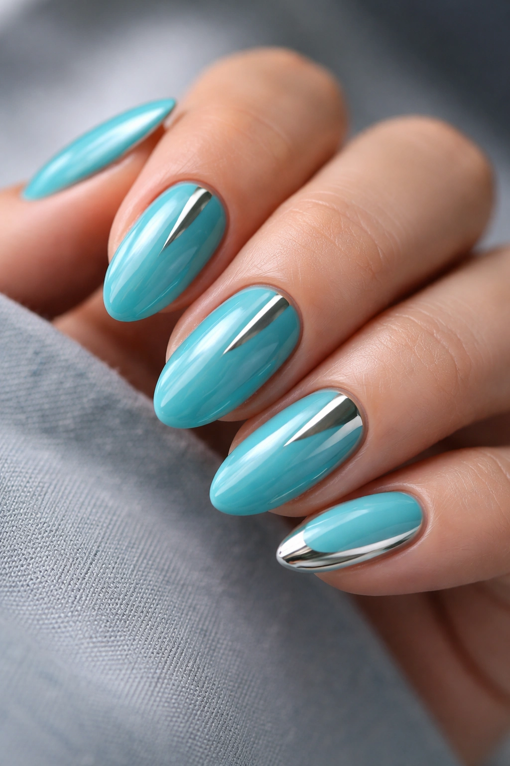Turquoise nails with silver chrome accents on short almond nails