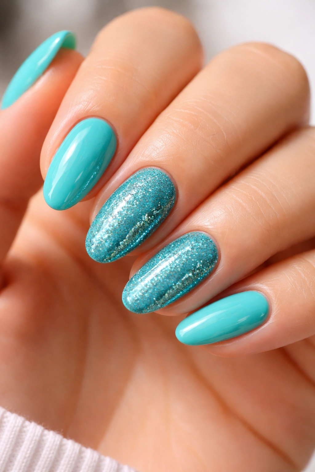 Turquoise nails with a glitter accent nail on short almond nails