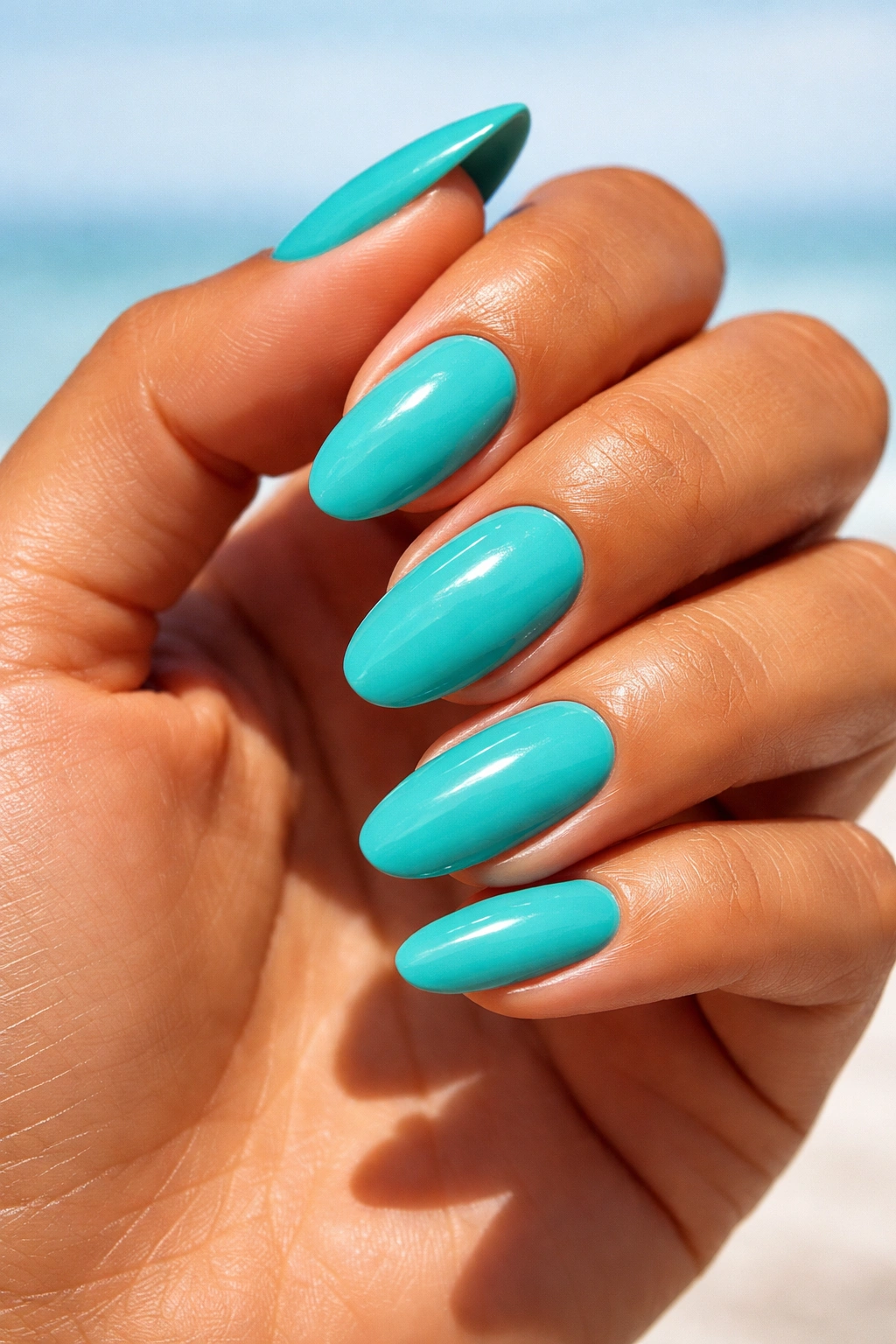 Close-up of turquoise nails on sun-kissed skin