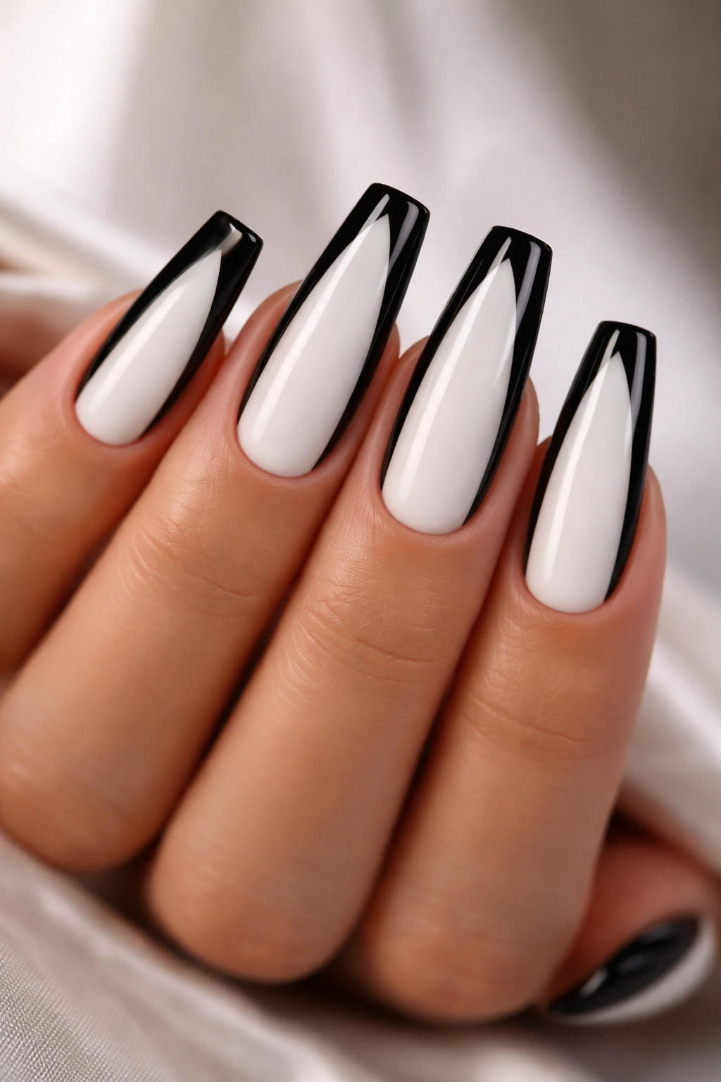 Nails with black side panels and a white center stripe on a ballerina shape