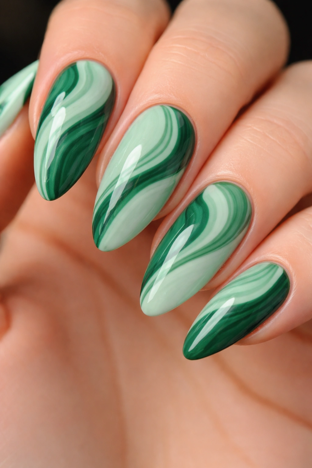Two-tone green swirl manicure on almond nails with mint and forest greens