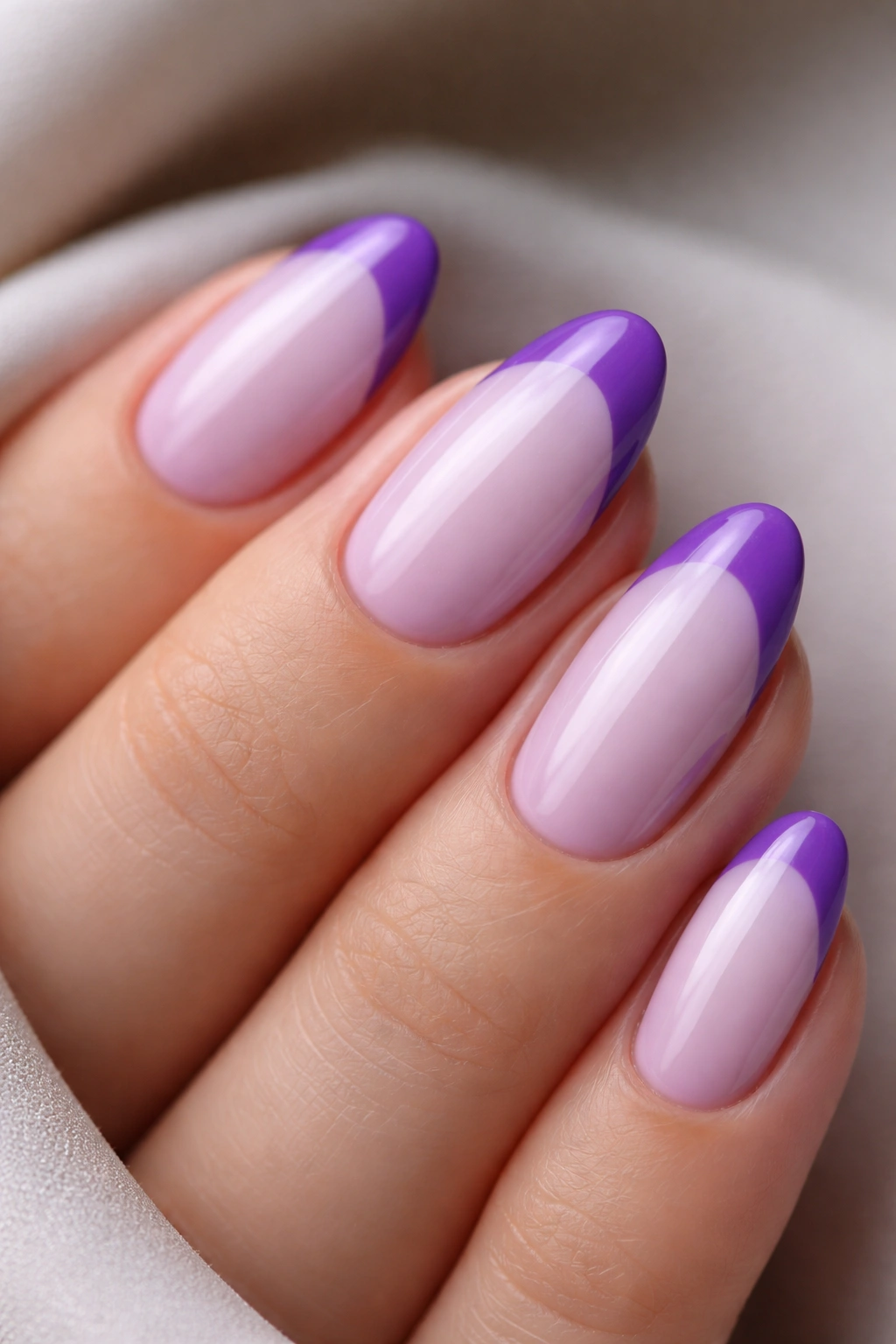 Close-up of a short almond nail with two-tone purple base and tip