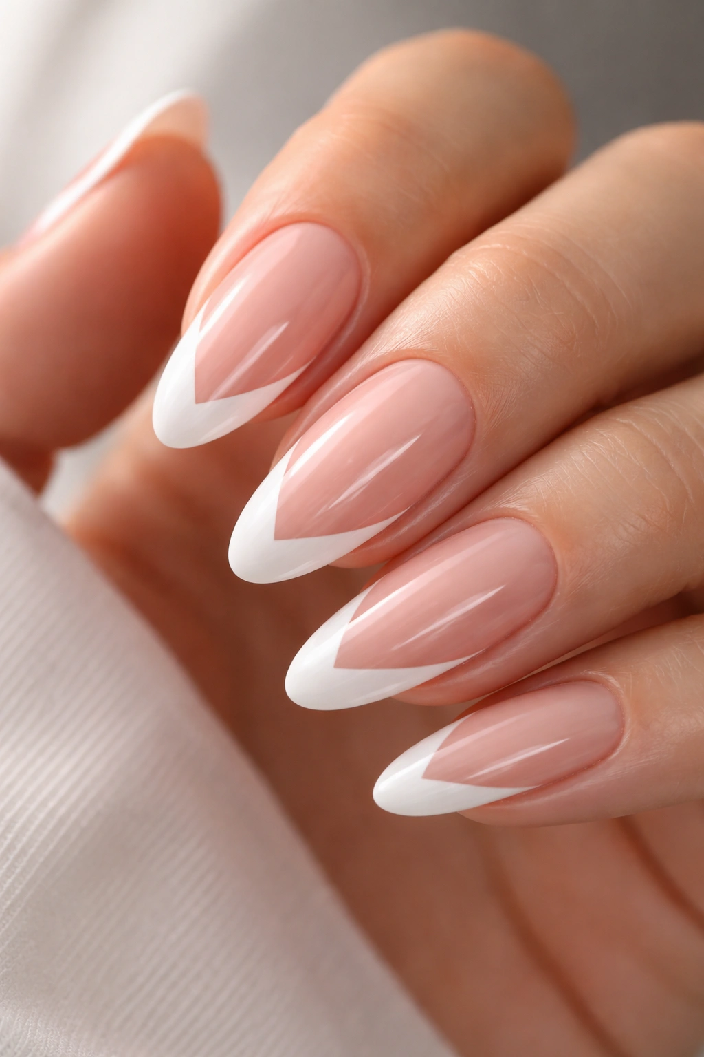 Close-up of long oval nails with centered V-shaped tips on pink base