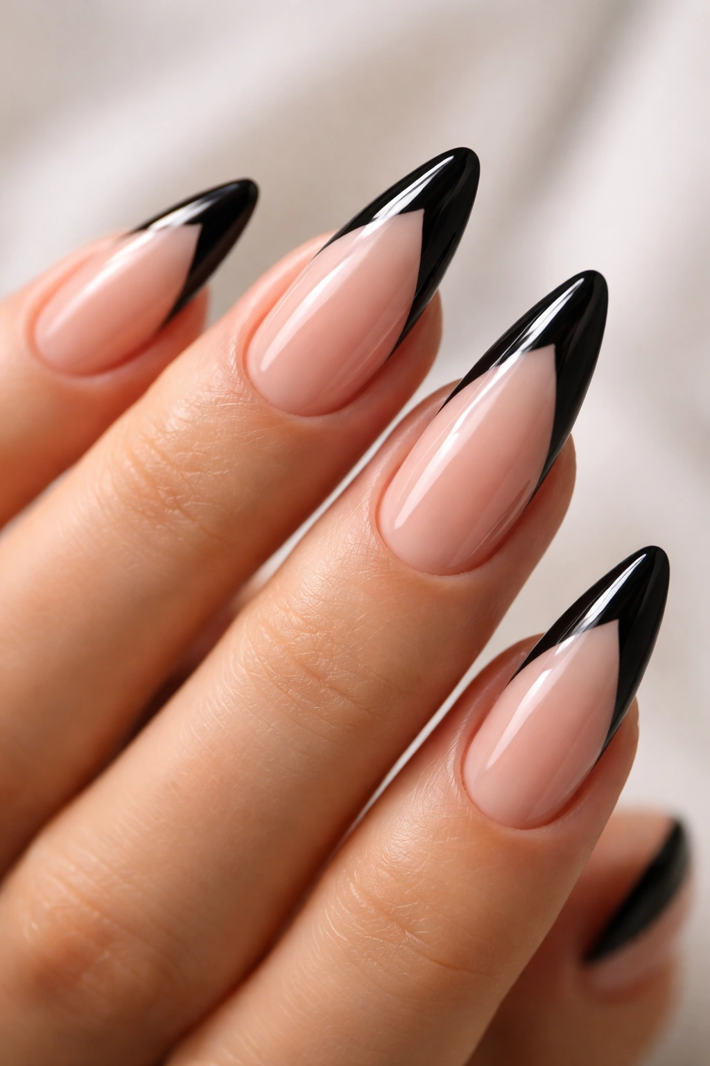Almond nail with a V-shaped black French tip at the center
