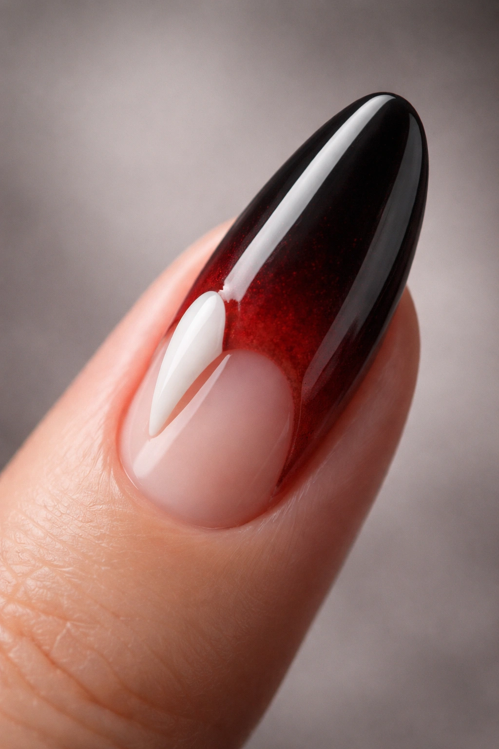 Close-up of a fingernail featuring a 3D vampire fang accent.