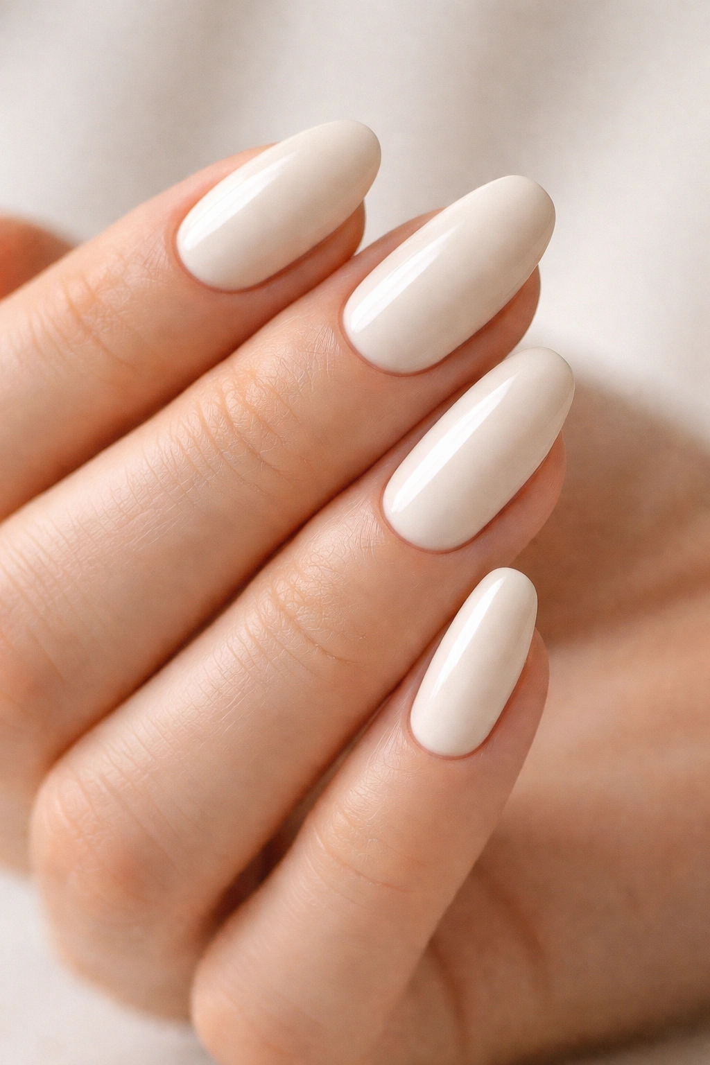 Close-up of vanilla cream nails on hands with warm undertones