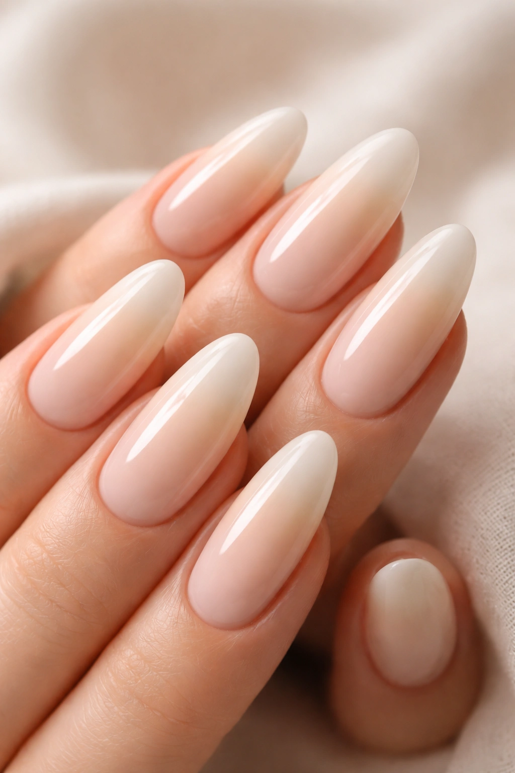 Close-up of long oval nails with a creamy vanilla ombre finish