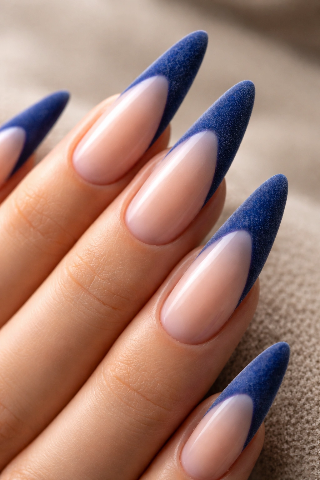 Velvet textured blue French tip nails on a stiletto nail