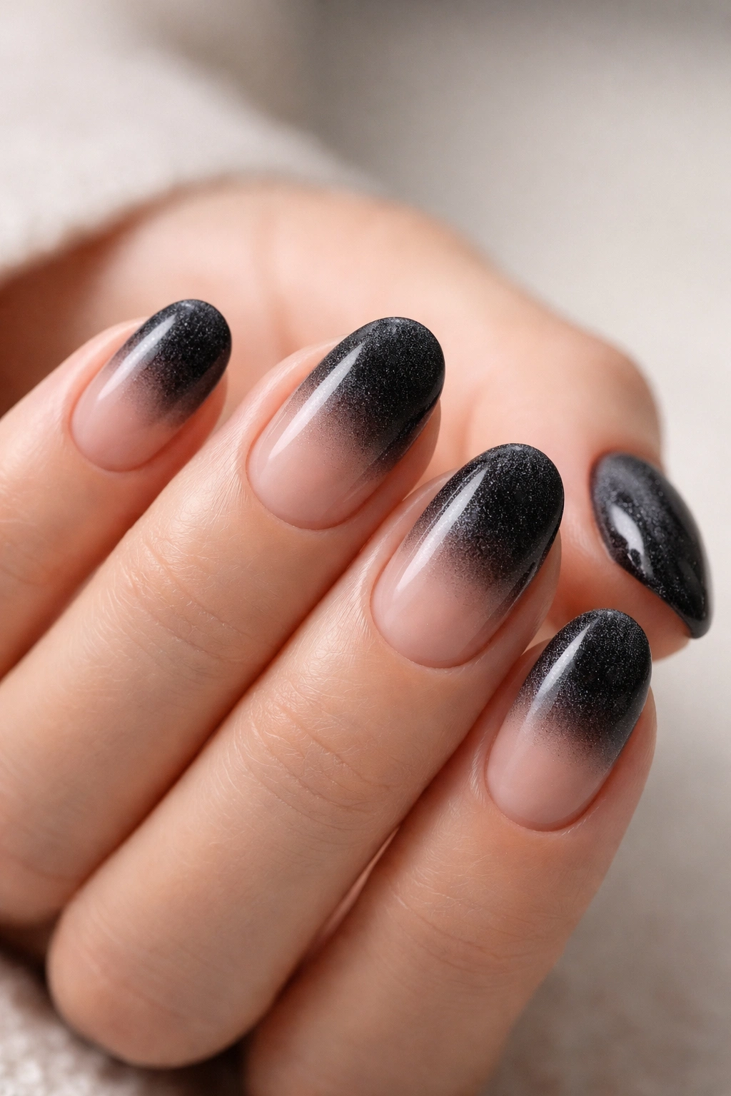 Close-up of short oval nails with velvet black tips showing plush texture