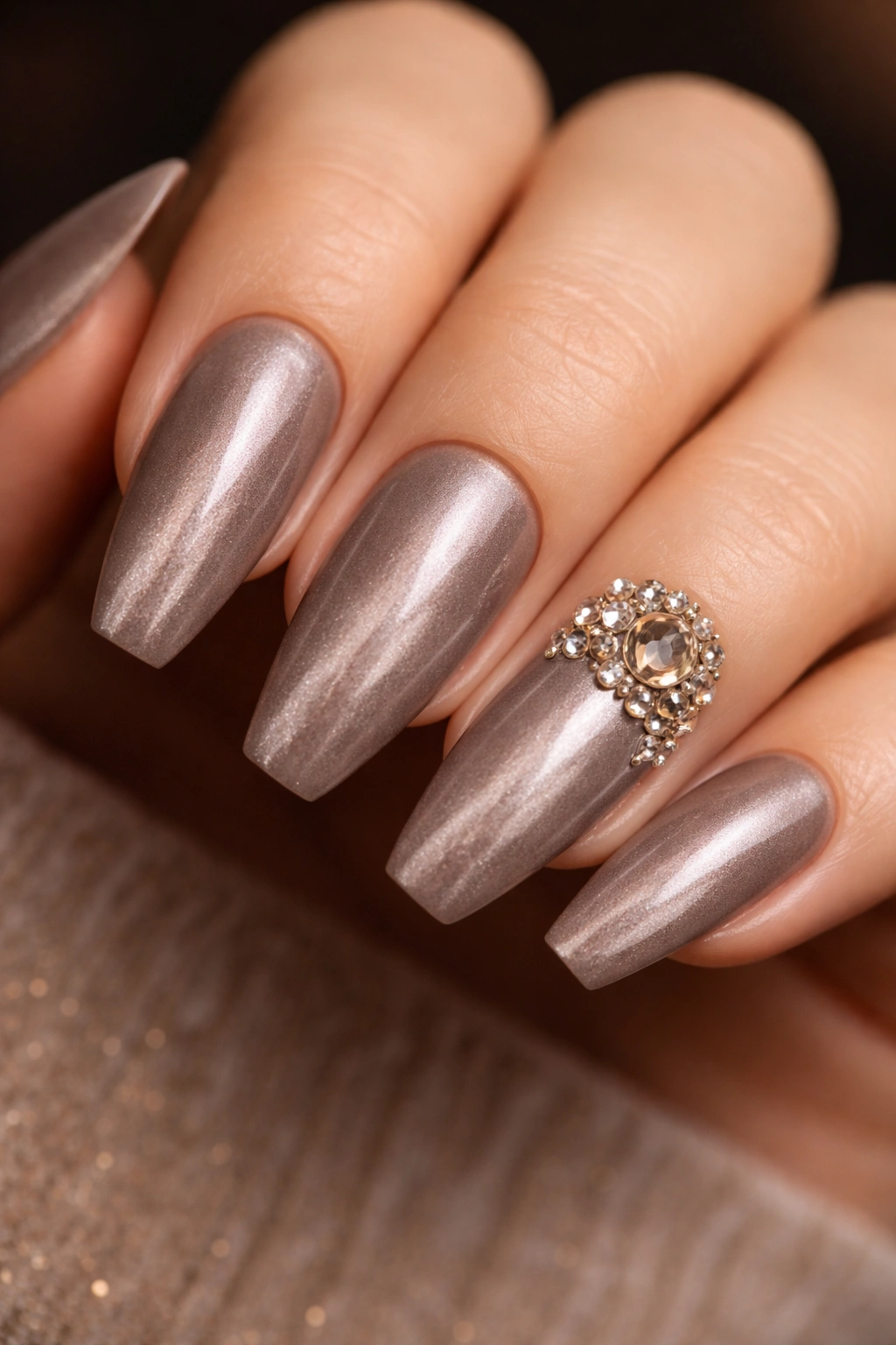Taupe velvet nails with a mixed-size crystal cluster near the cuticle