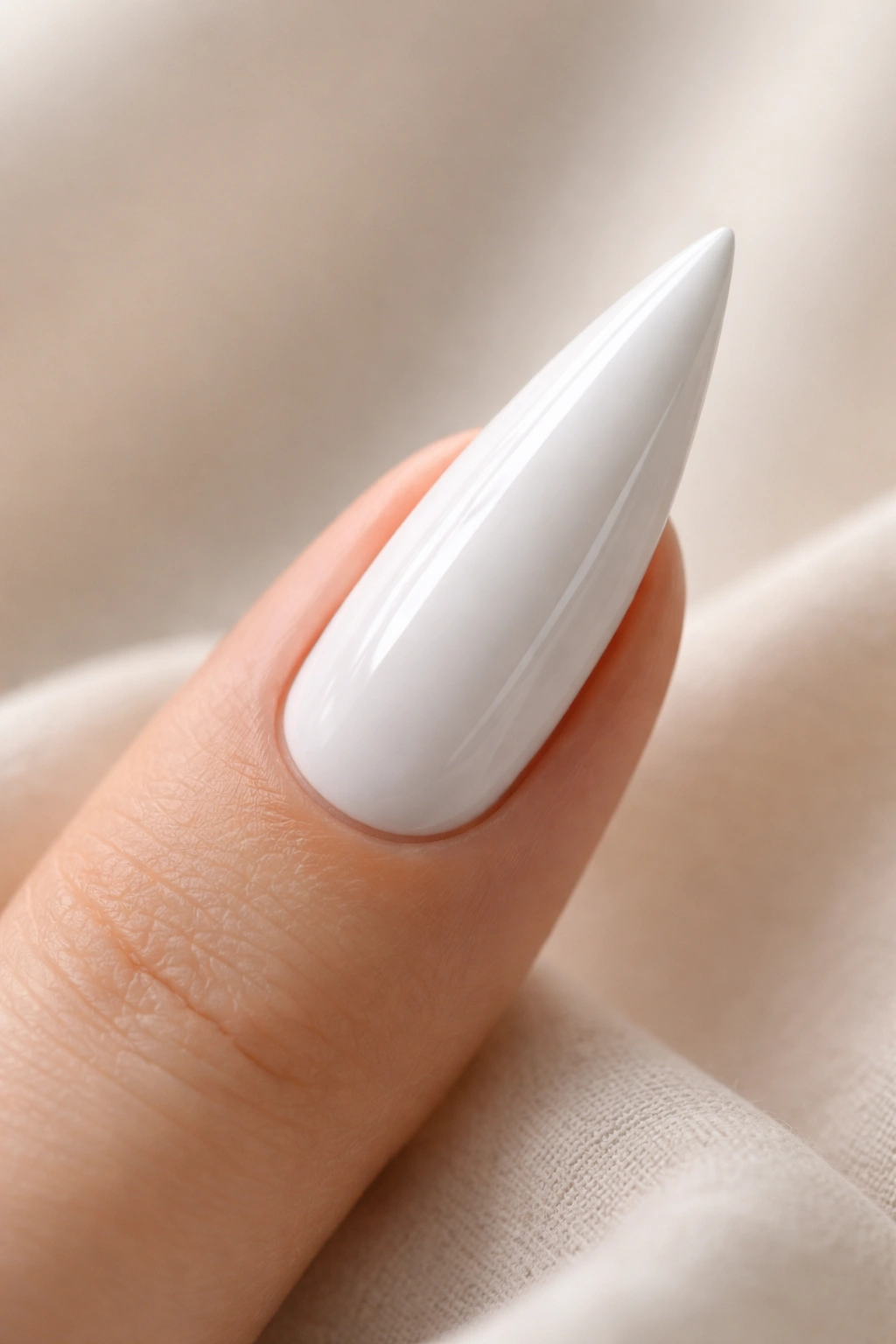 Close-up of a white stiletto nail on a neutral background symbolizing versatility