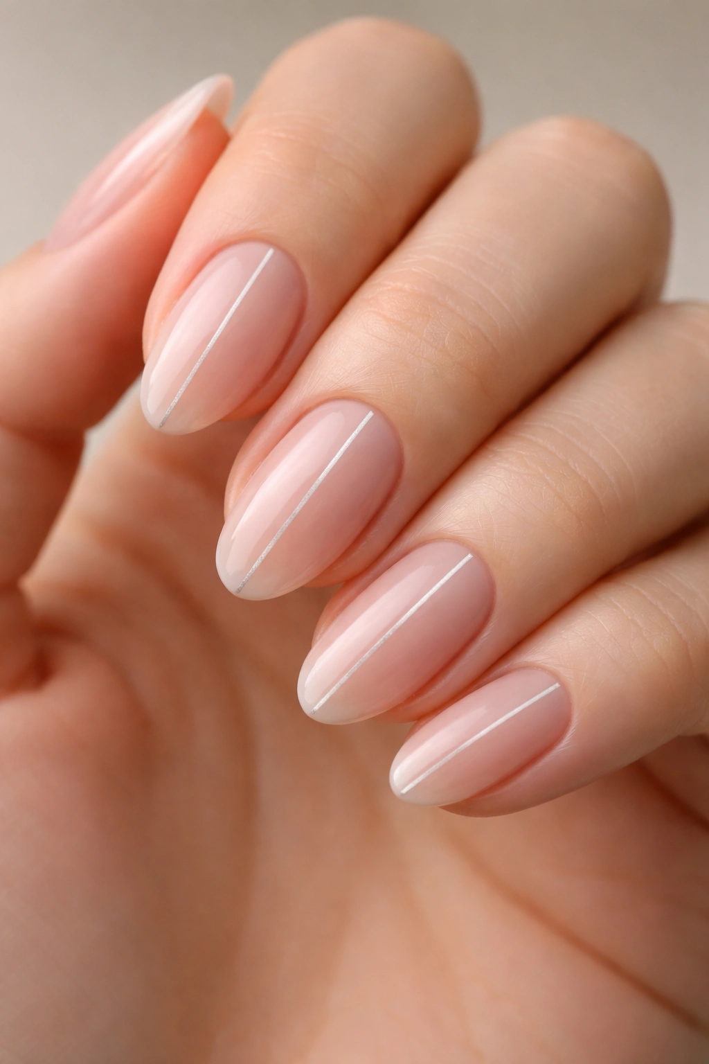 Close-up of short almond nails with a single vertical line accent