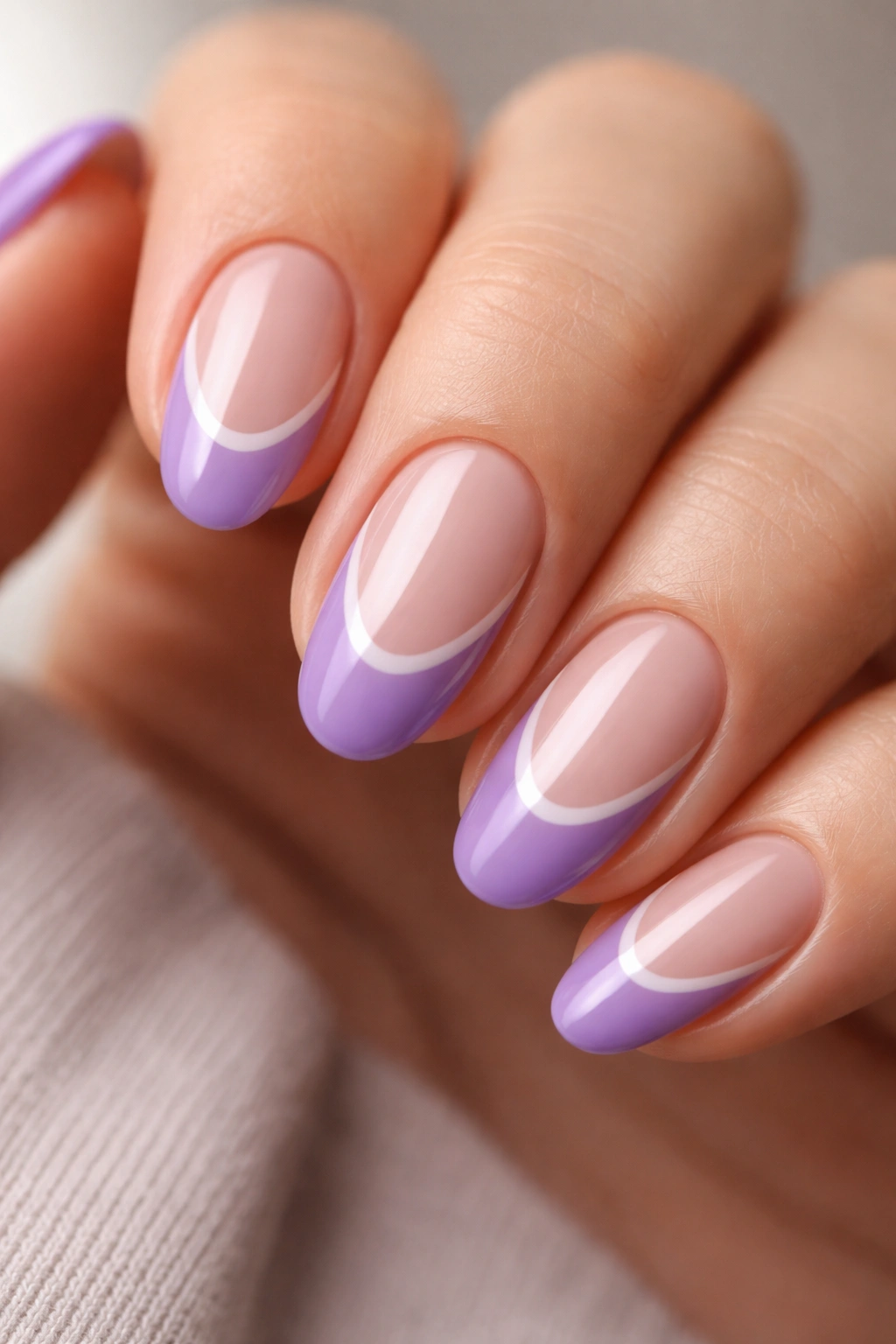Close-up of a violet French tip with negative space on a short almond nail