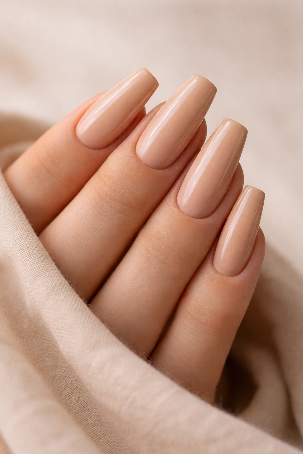 Close-up of medium coffin nails with warm beige base and subtle tan lines