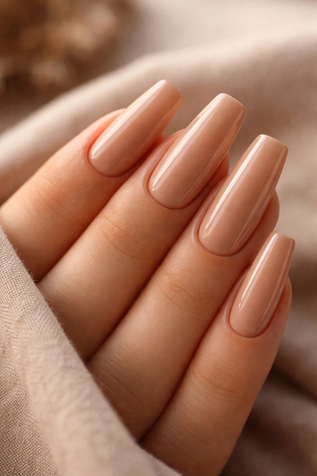 Close-up of warm latte nude manicure with full opacity on ballerina nails