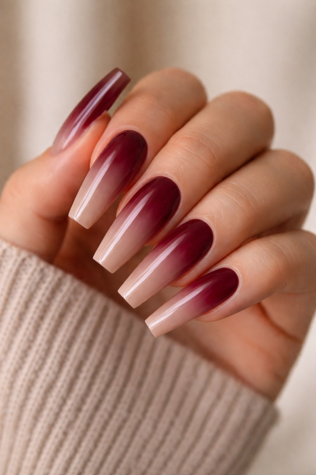 Close-up of coffin nails with burgundy base fading to warm taupe (reverse gradient).