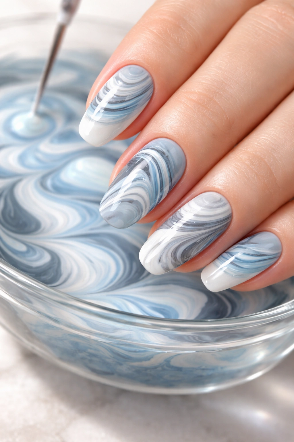 Close-up of water marble nail designs with swirling colors on fingernails