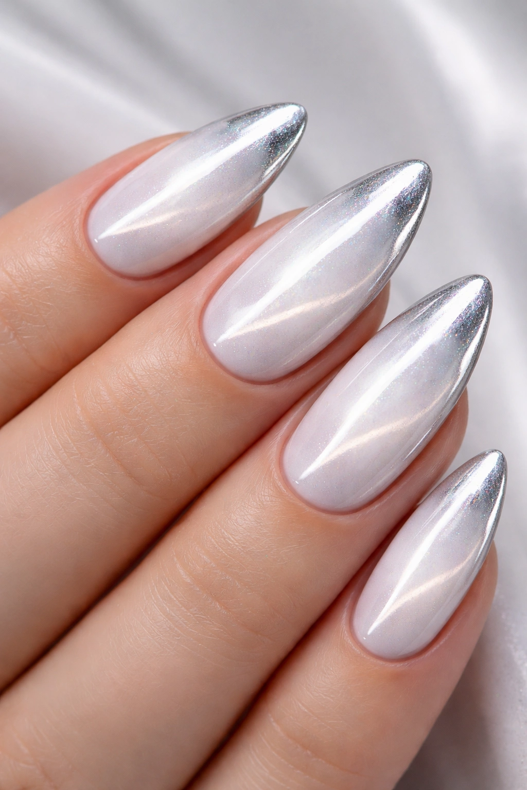 Close-up of white cat eye nails with chrome powder accents and mirror-like highlights