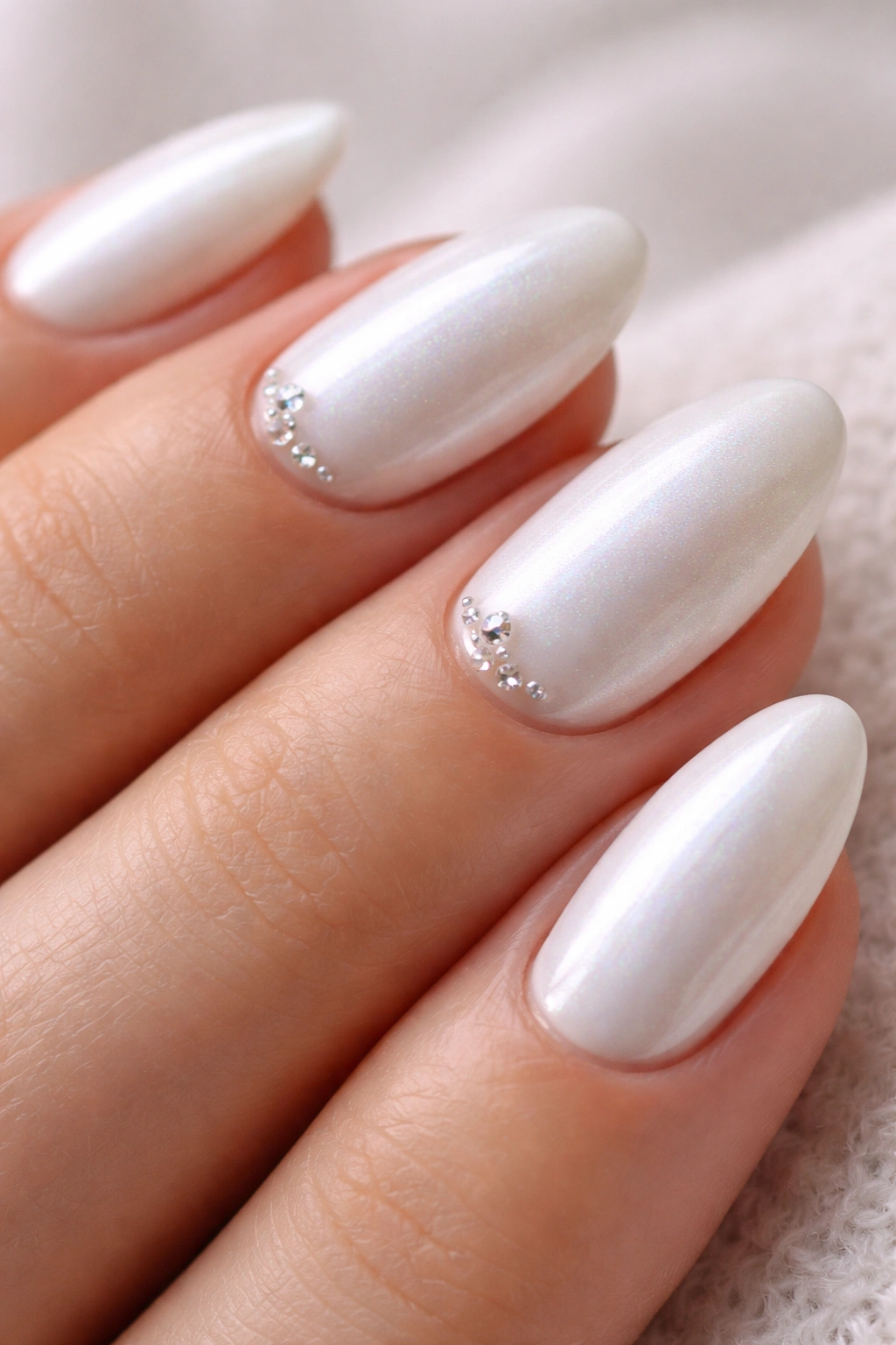 Short almond nails with white chrome and tiny crystals near cuticles