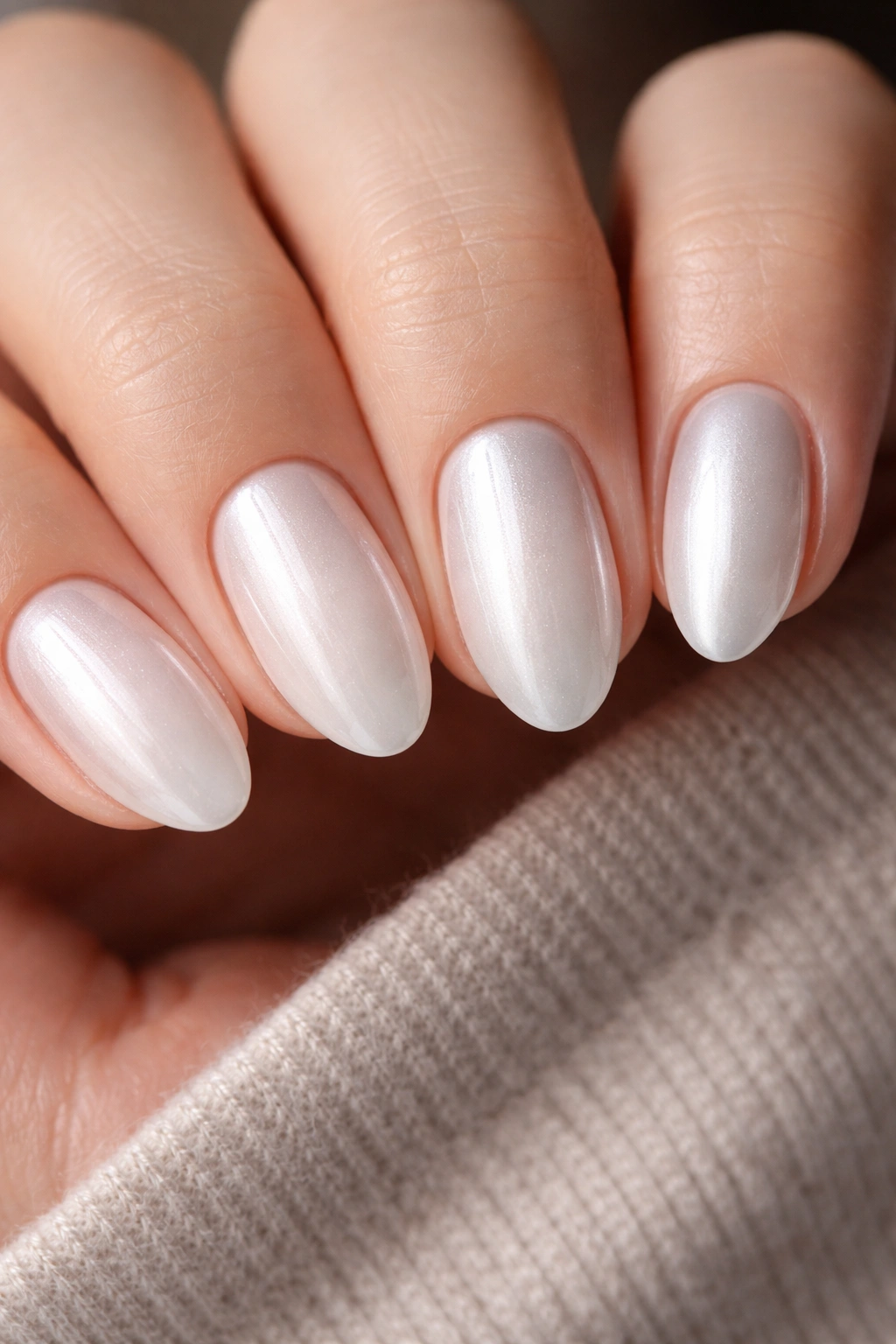 Short almond nails showing pearly icy and silver white chrome finishes
