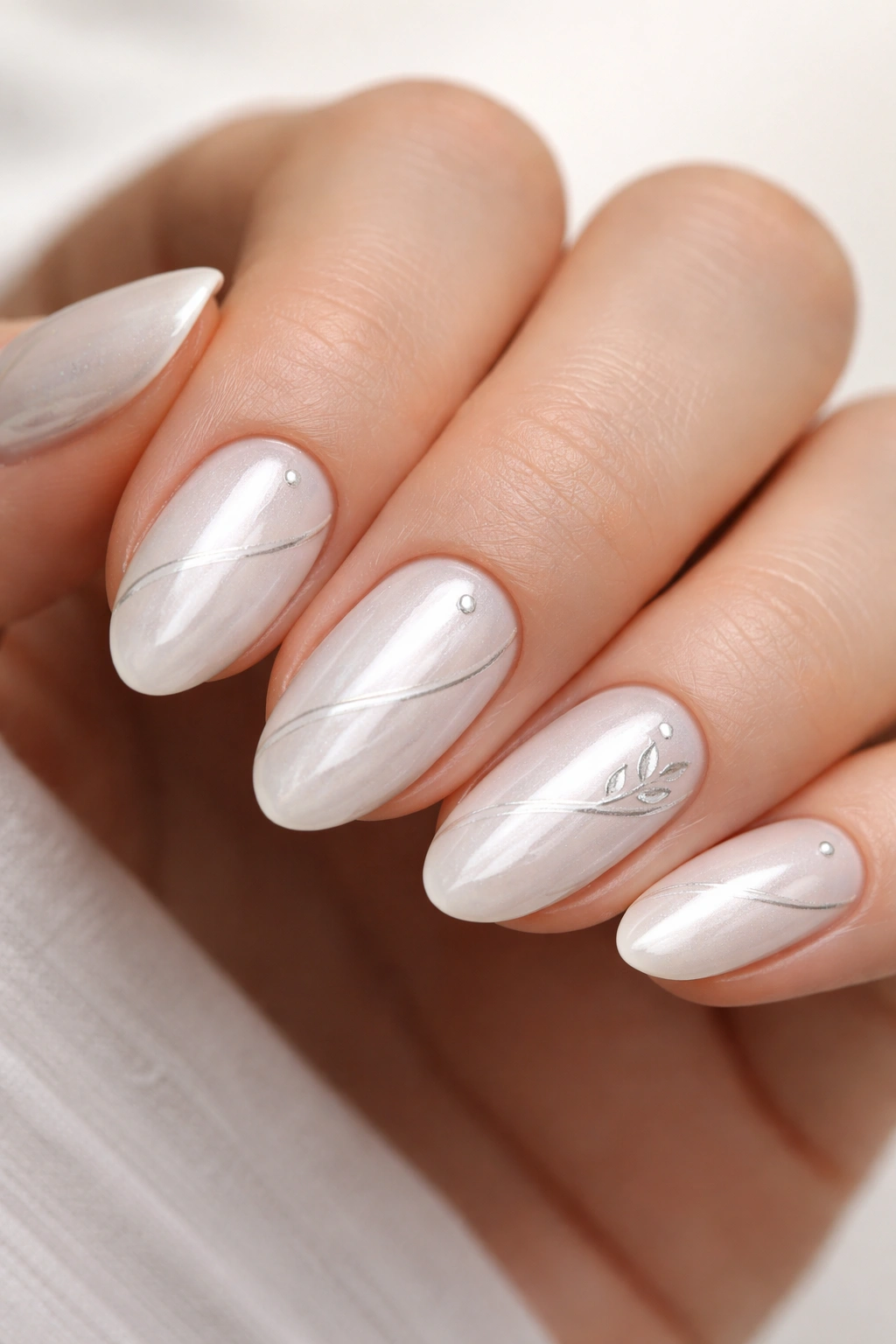 Close-up of short almond nails with white chrome and fine white line art
