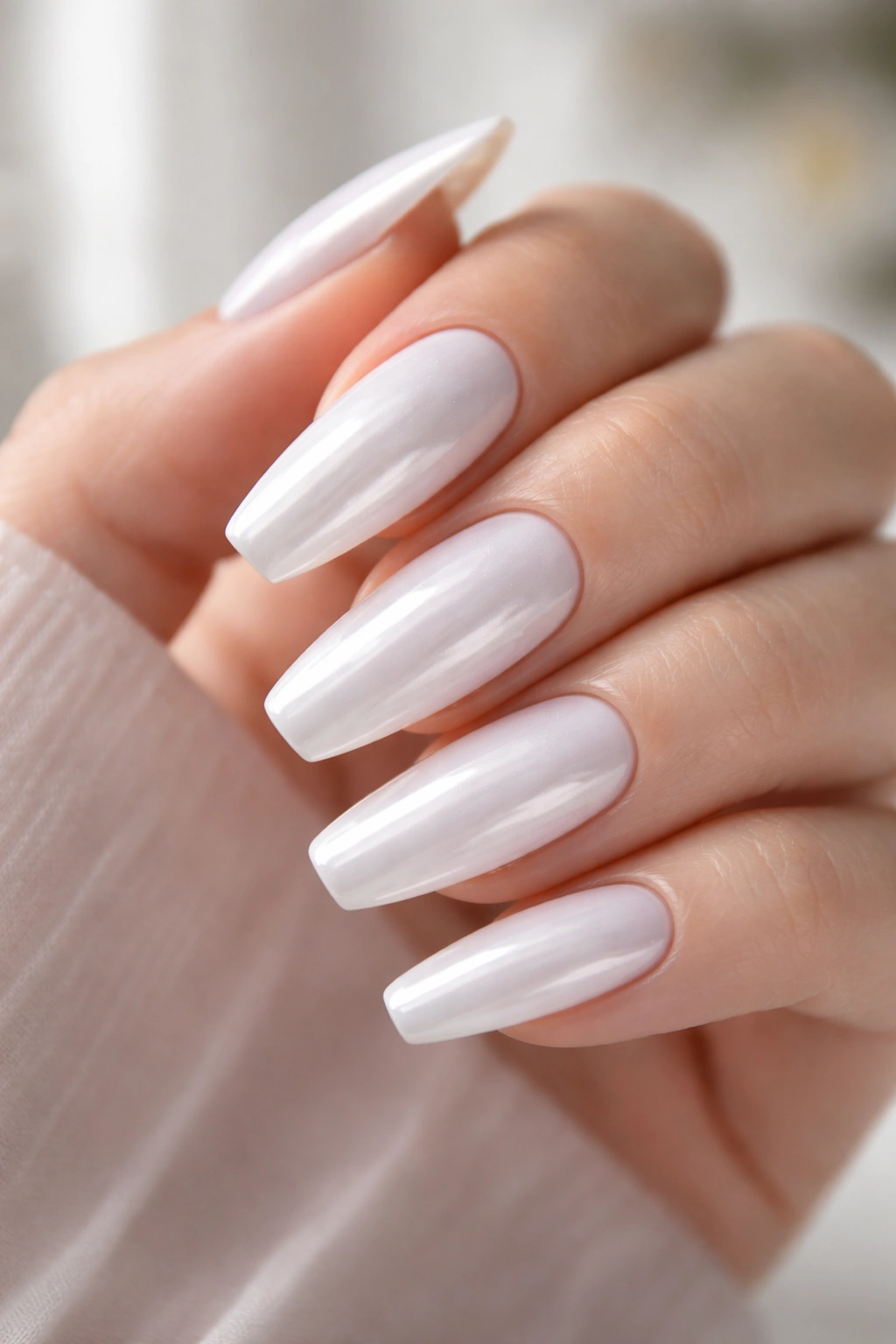 Bright white chrome ballerina nails in a clean studio setting