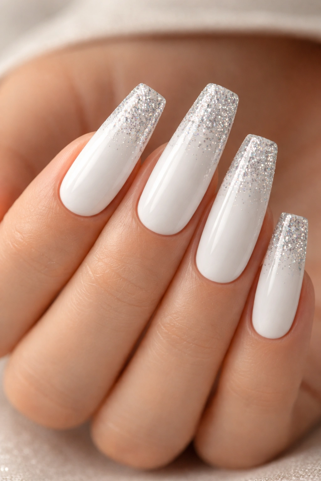 White coffin nails with glitter tips on a neutral background
