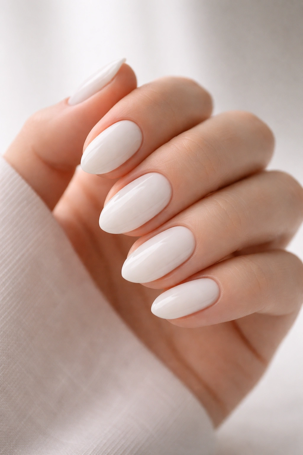 Close-up of short almond nails in off-white dip powder with a soft almond curve