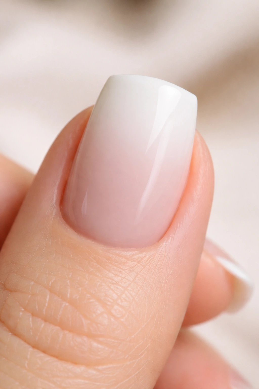 Close-up of white duck nail with gradient from white tip to nude base on short nail