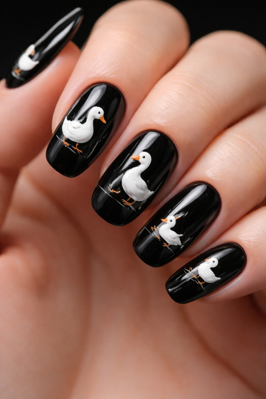 Close-up of white duck silhouettes on a deep black nail background.