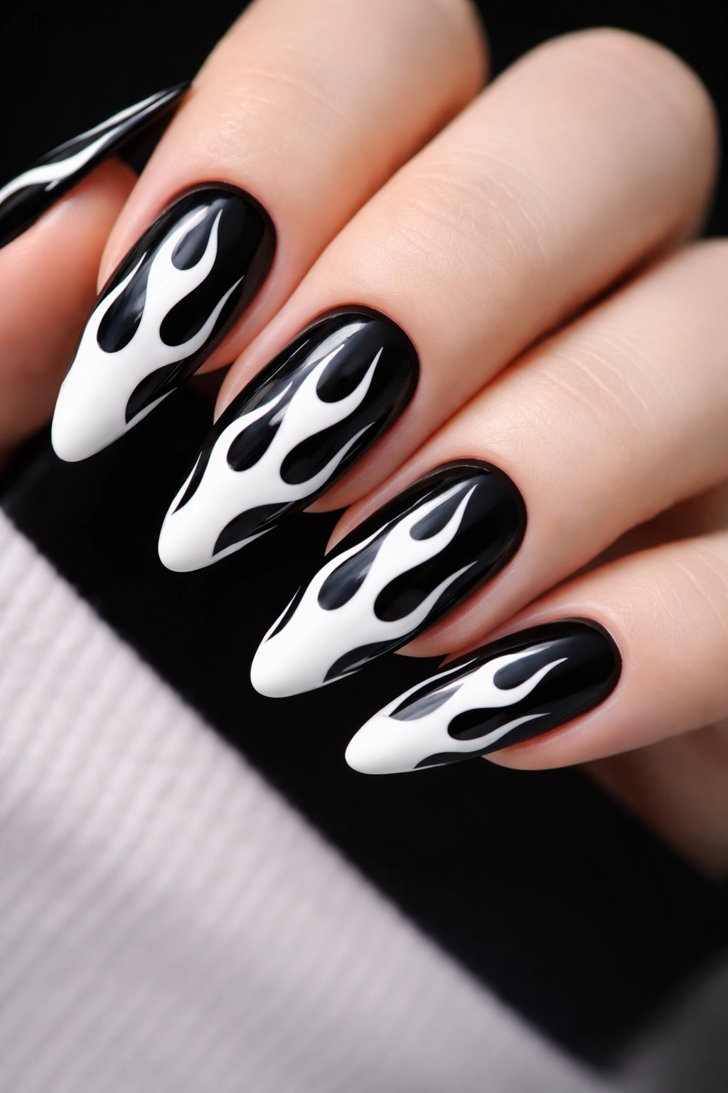 White flame nail art on a dark base