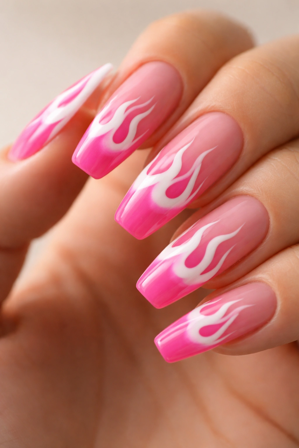 Close-up of white flame tip art on hot pink base nails
