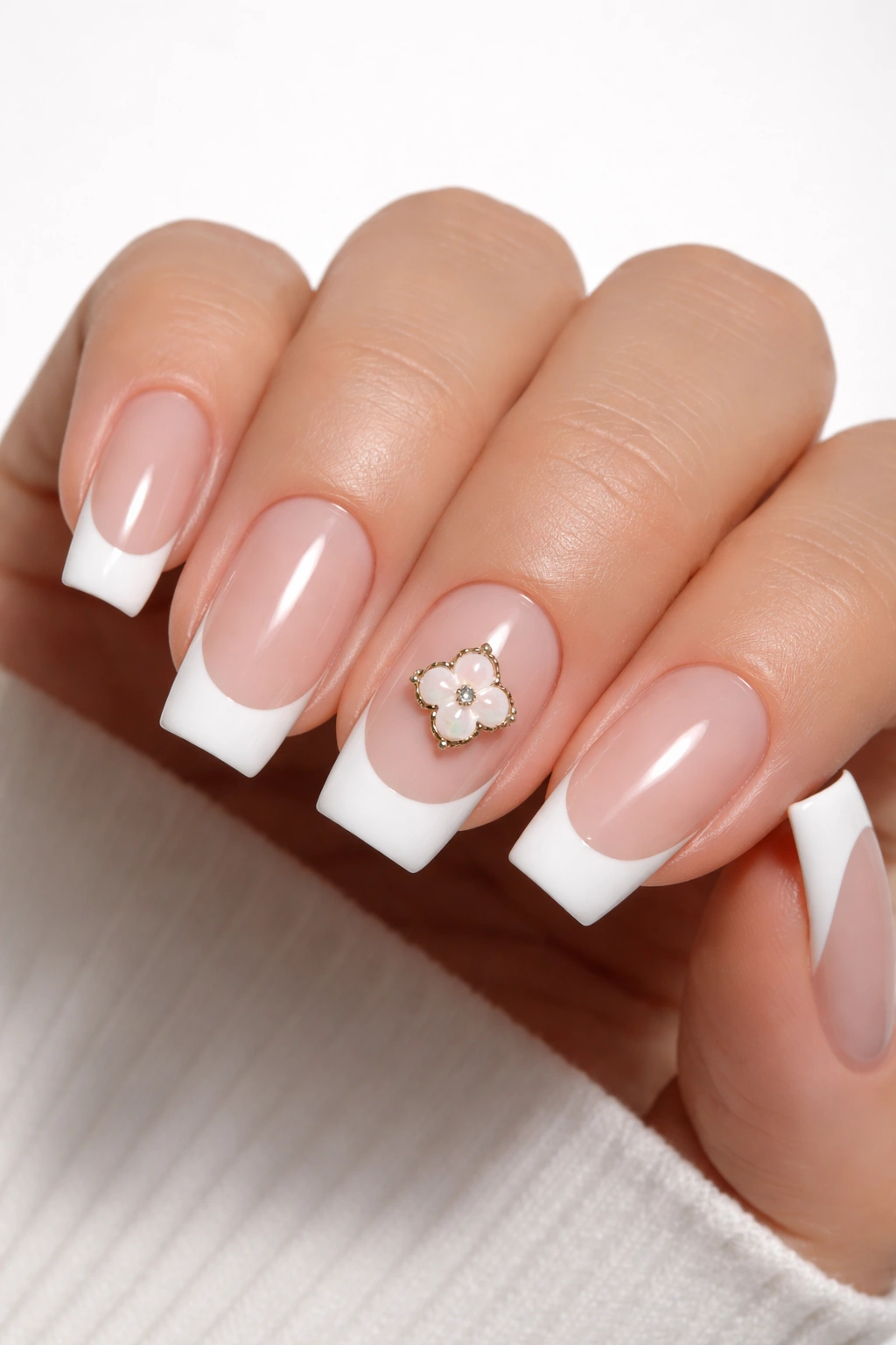 Nails with white tips and a single clover charm accent nail