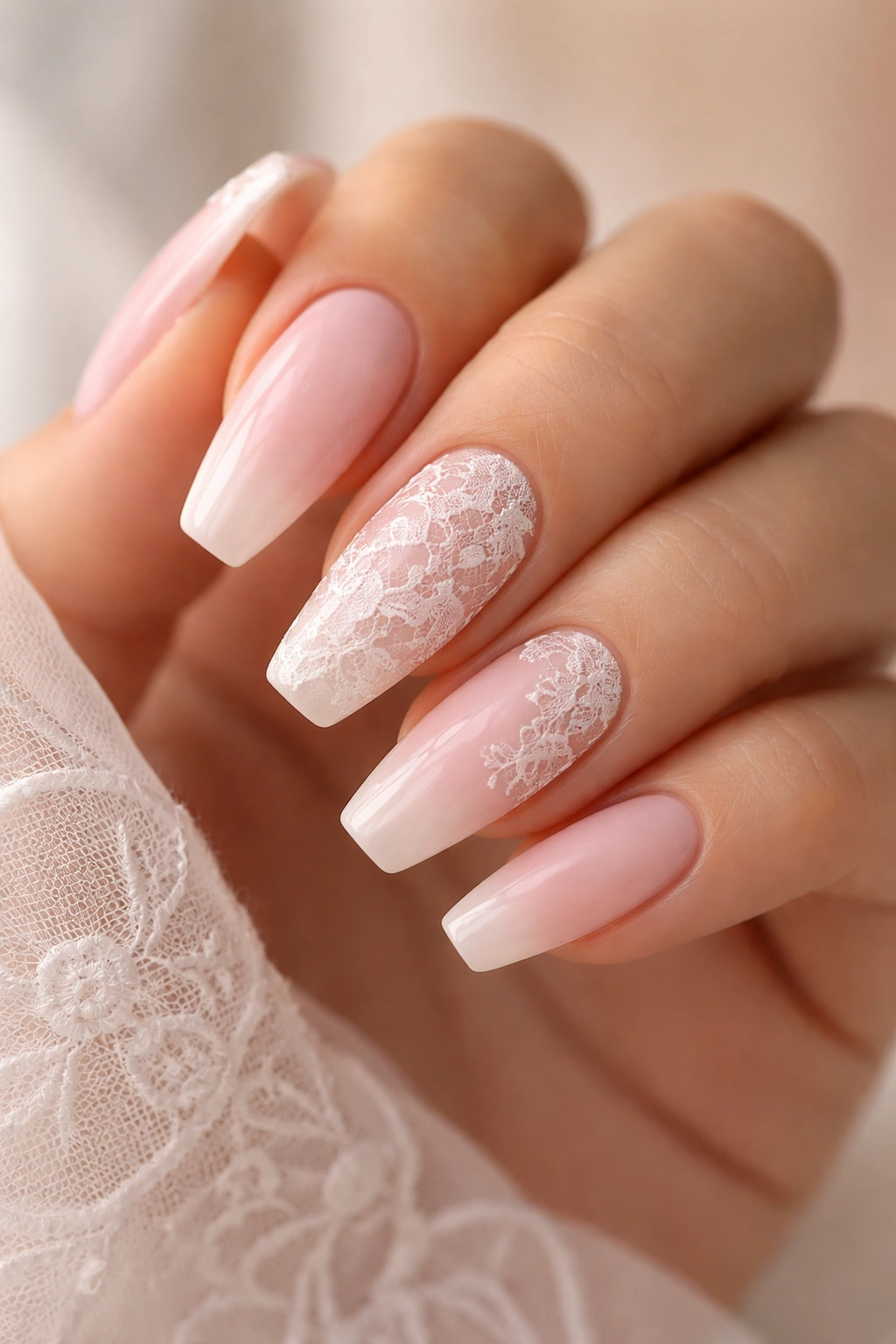 Close-up of white lace nails on soft pink solids with delicate lace pattern