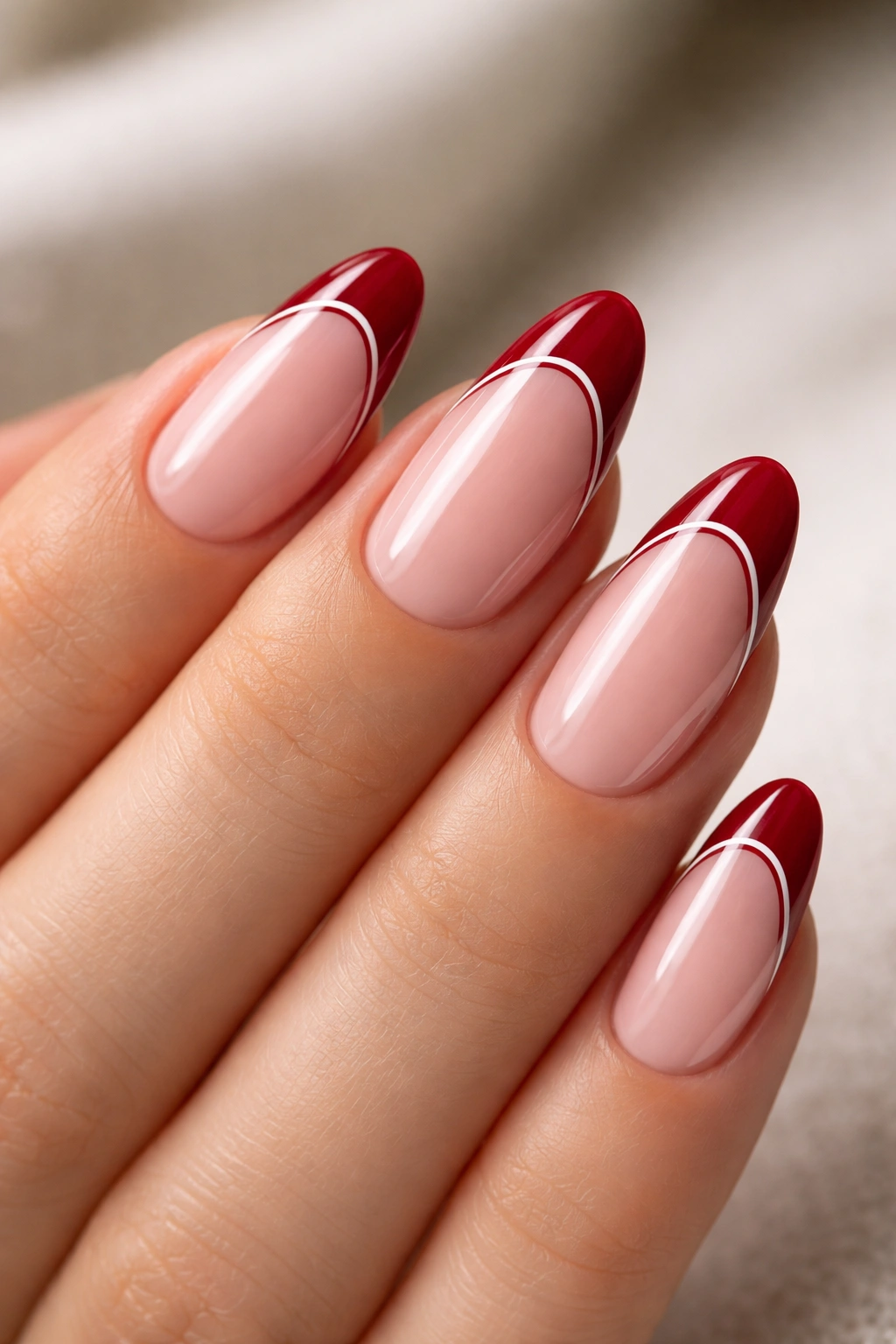 Almond nails with deep red tips and thin white liner along smile line