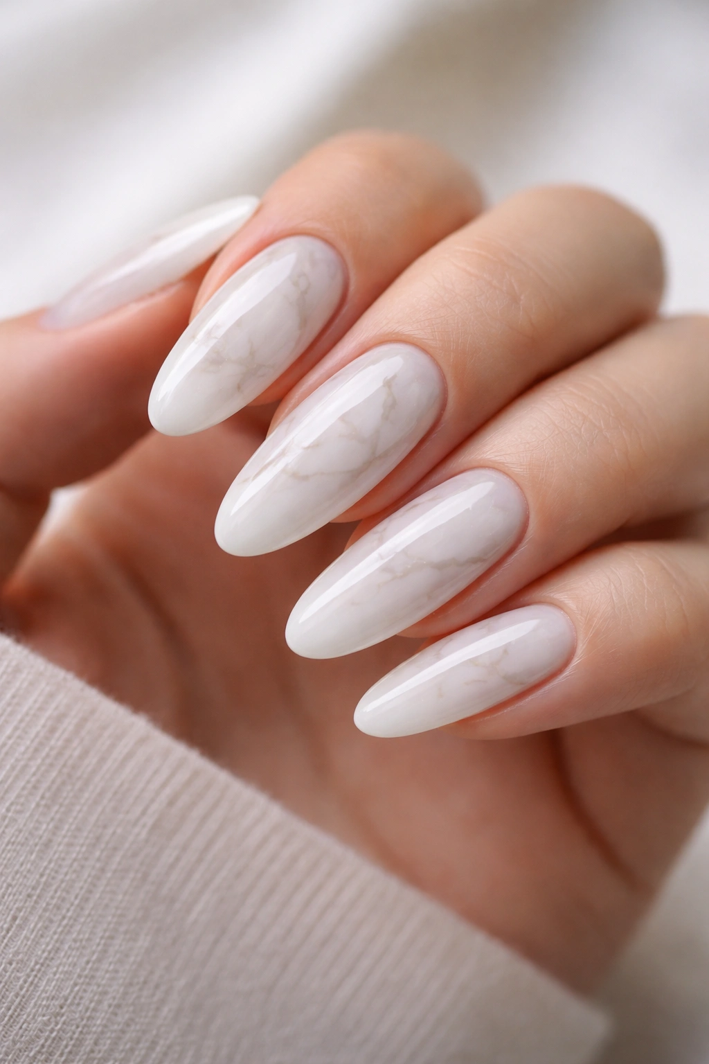 Close-up of white marble long oval nails with gray veining