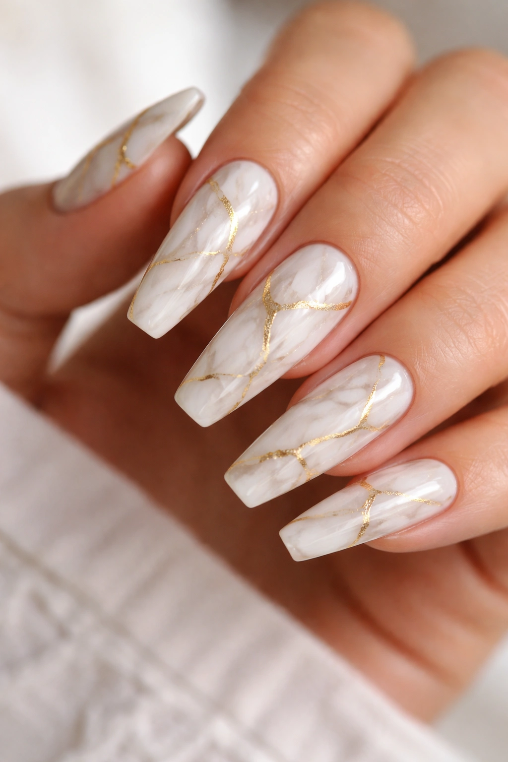 White marble nails with fine gold veining on ballerina shape.