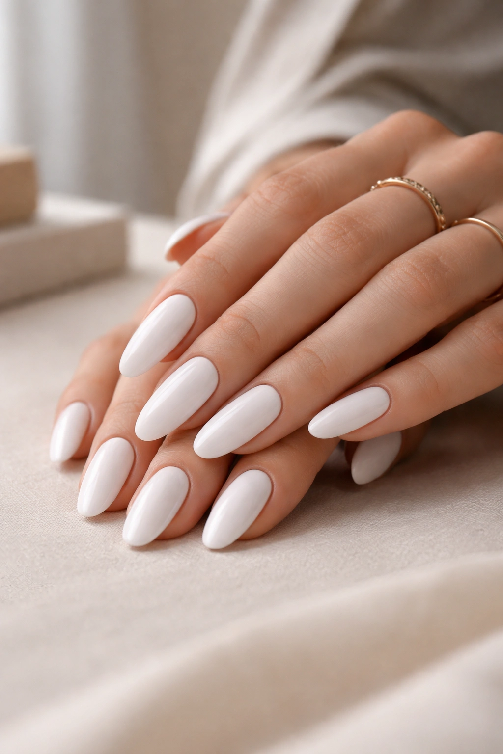 Close-up of white long oval nails on a clean surface