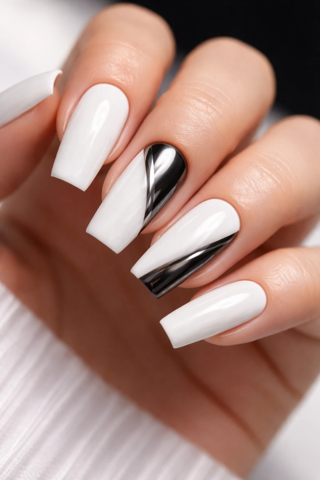 Nails with glossy white base and black chrome accents