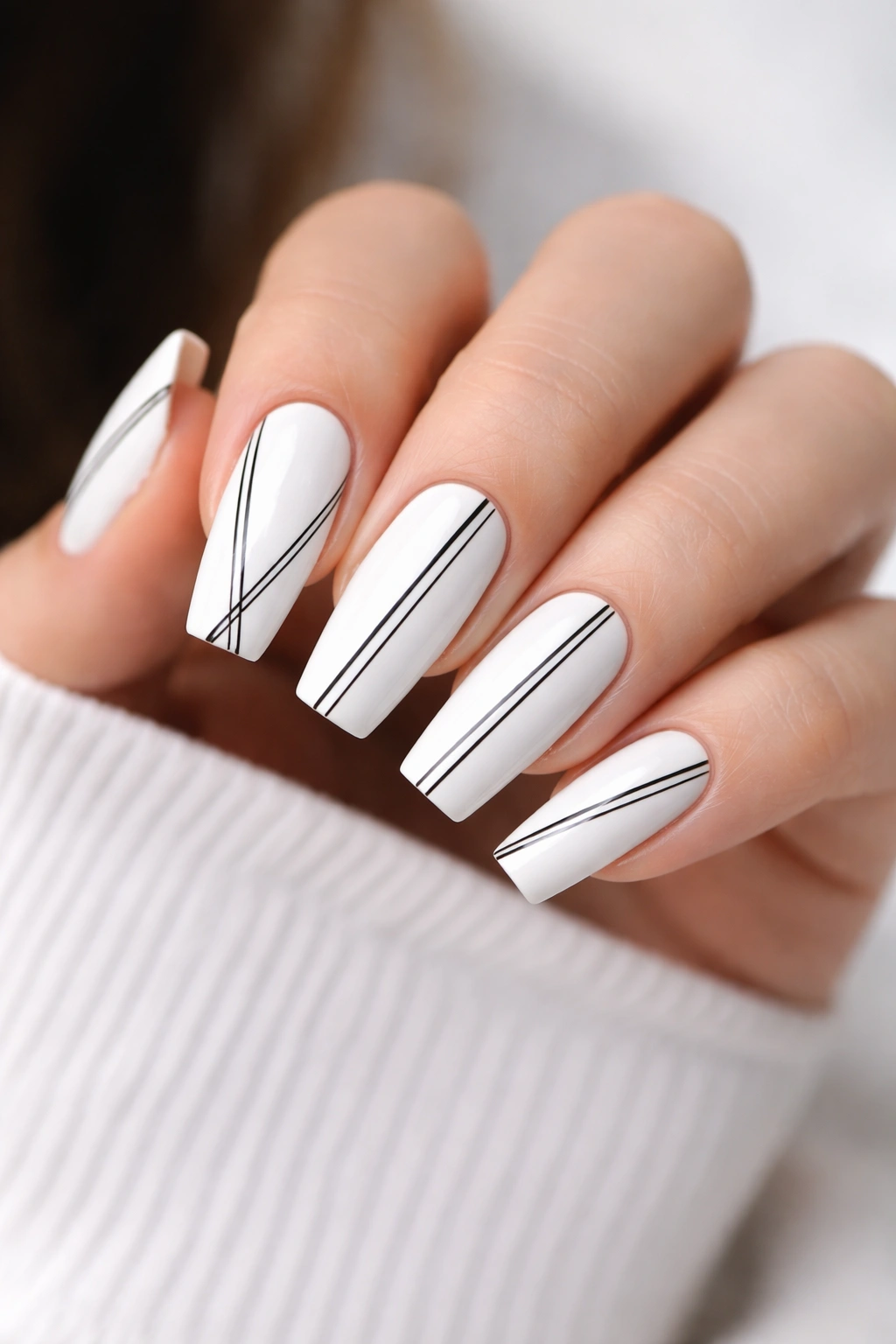 Close-up of white coffin nails with thin black stripes