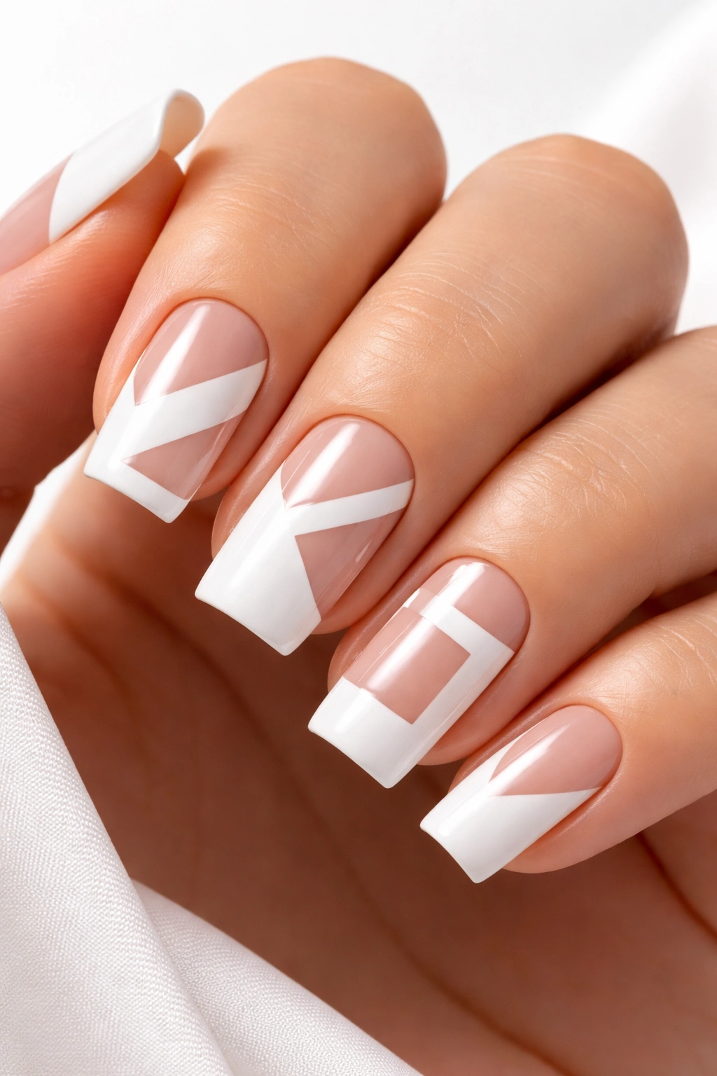 Close-up of white geometric nails with negative space design