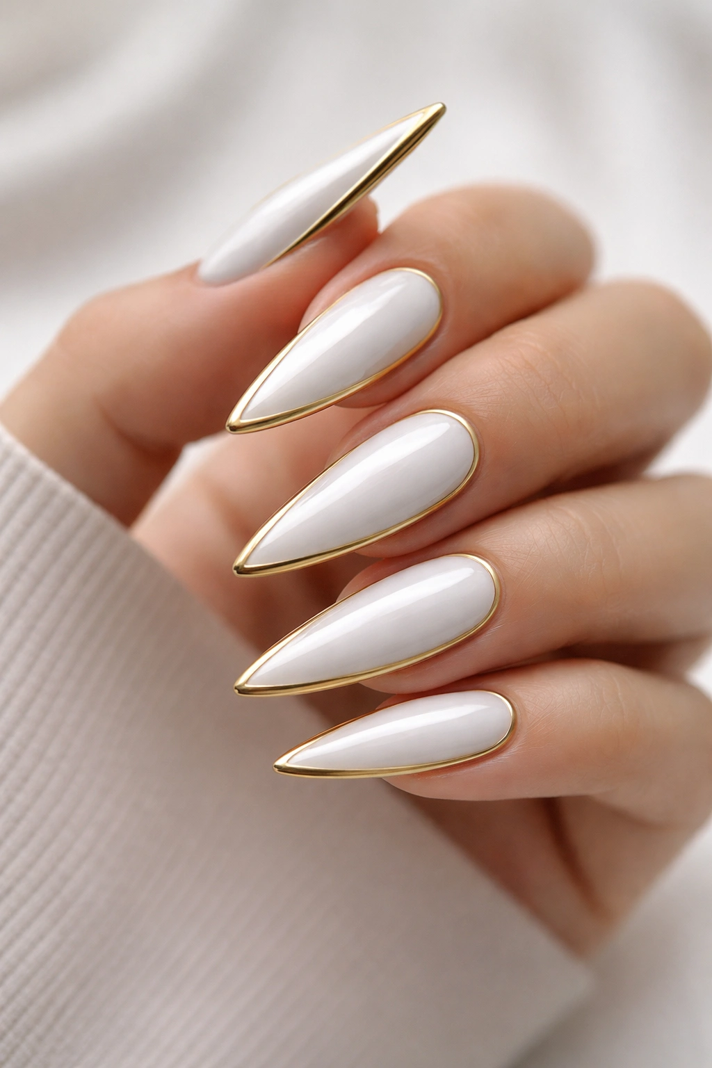 White stiletto nails with a gold border frame