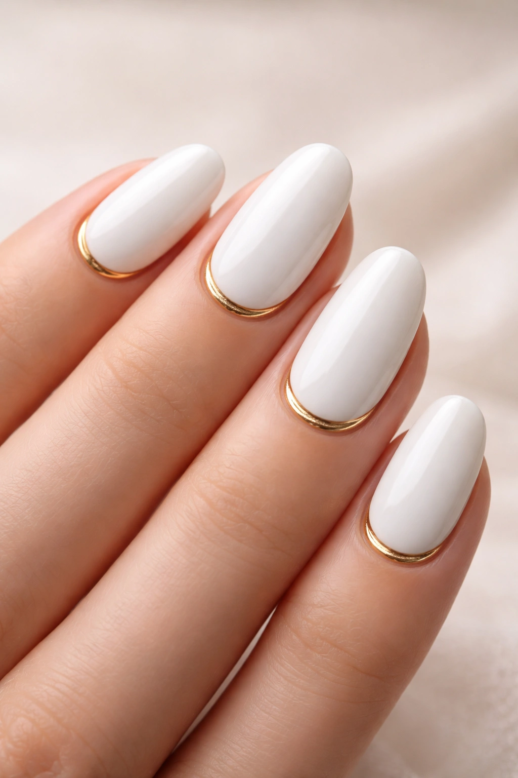 White nails with a delicate gold arc along the cuticle