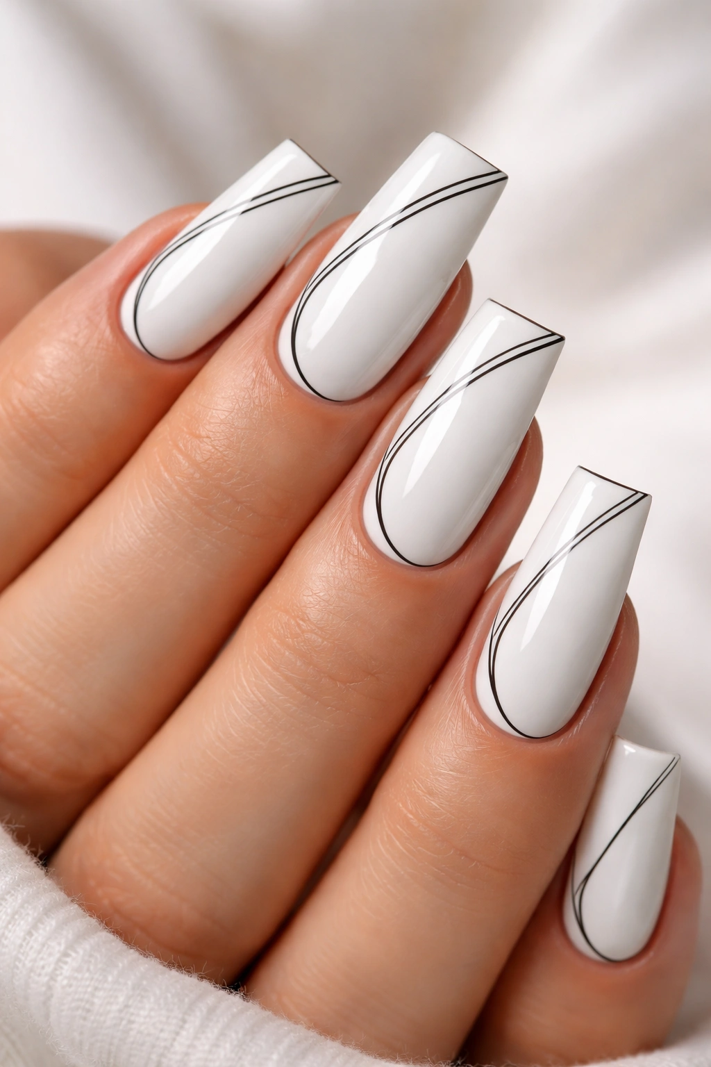 Close-up of white nails with delicate black line work on medium duck nails