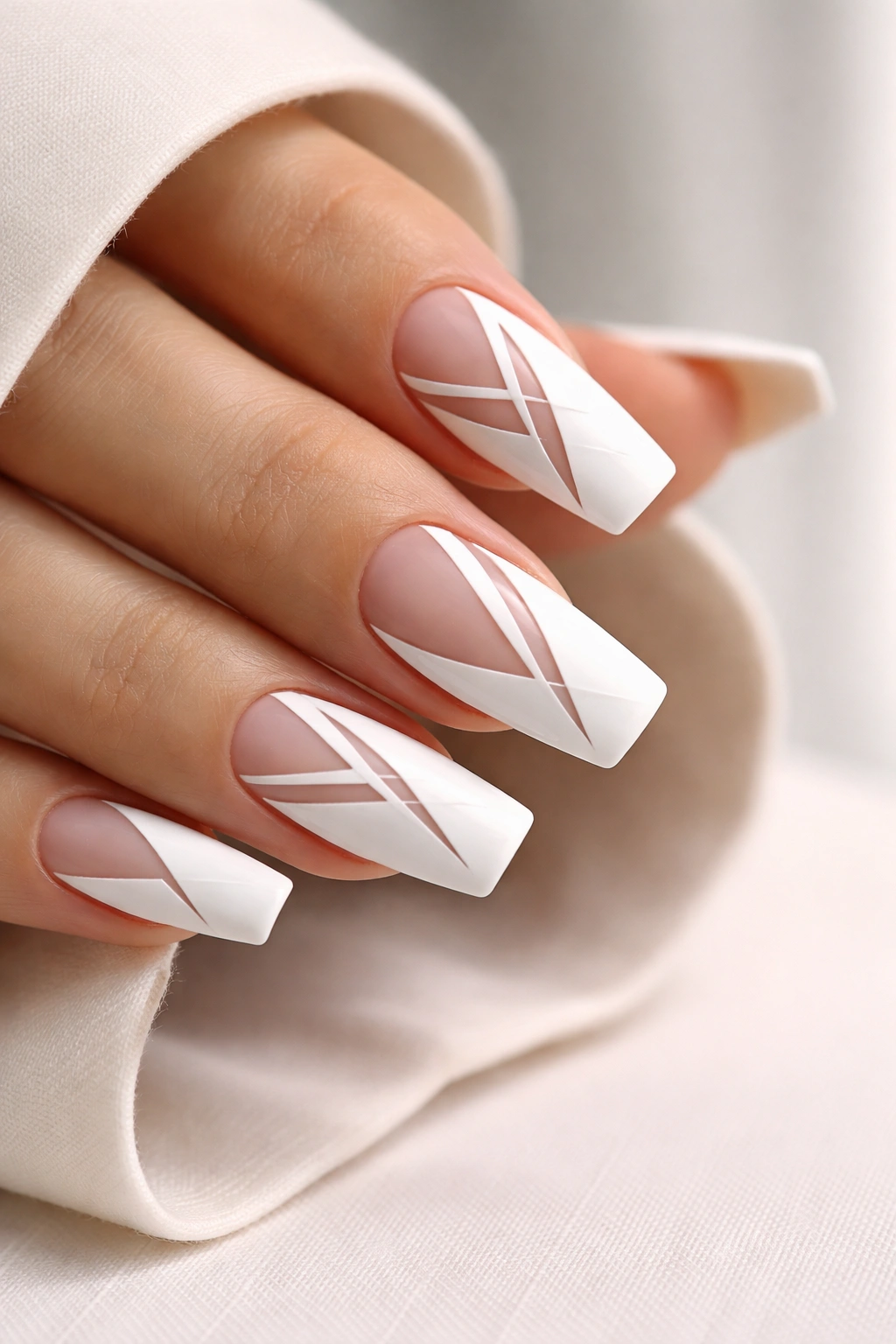 Close-up of white nails with negative-space geometric shapes