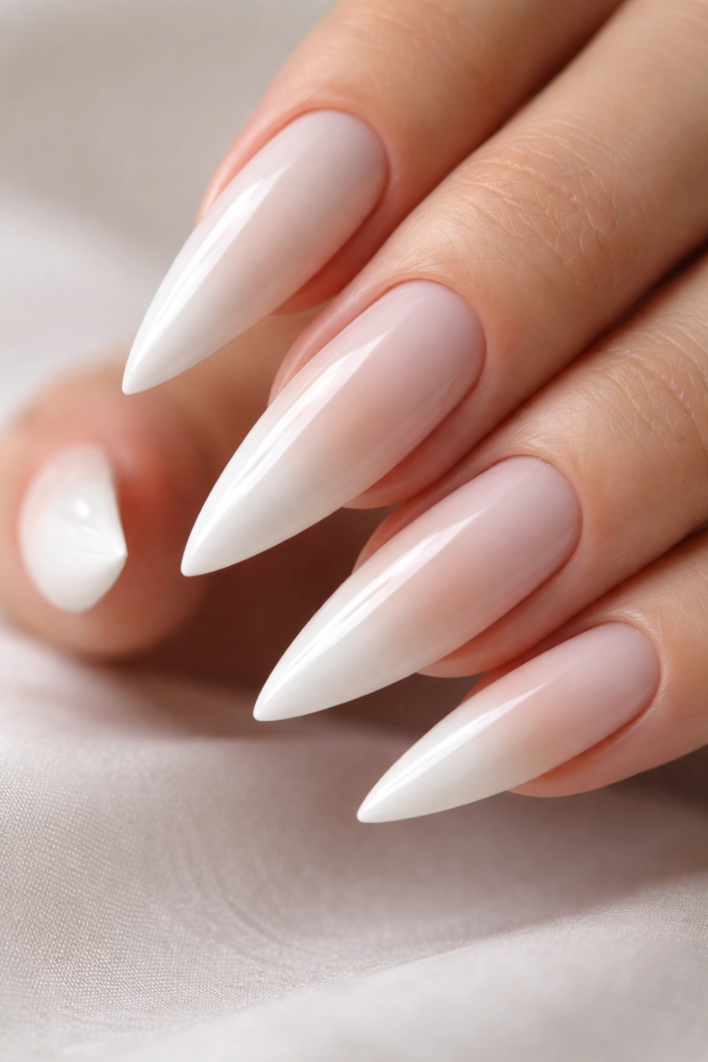 Close-up of nails with white base and nude-tipped gradient