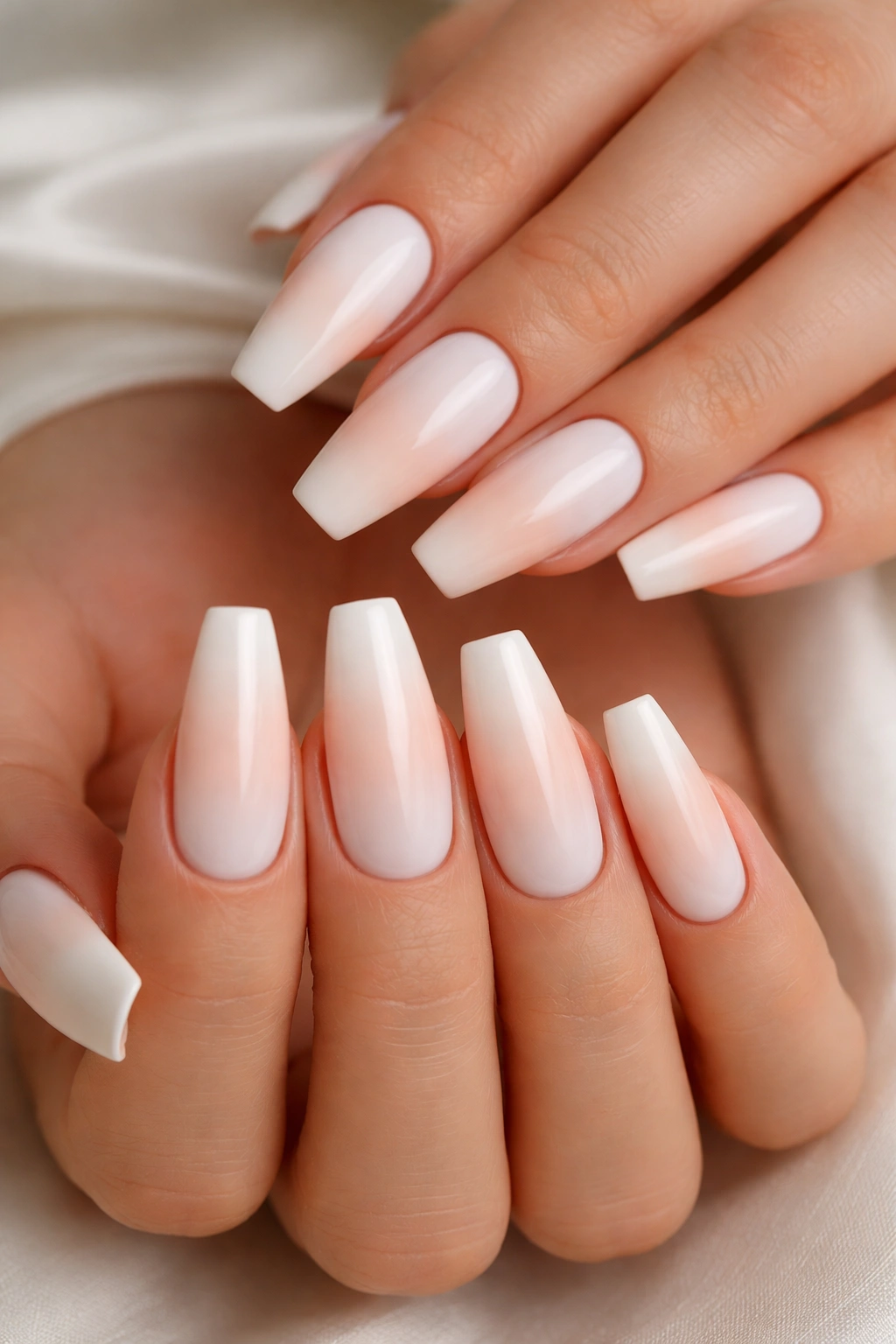 Close-up of white nails with a pale ombre accent transitioning to blush along the edge.