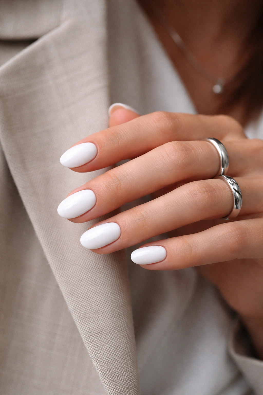 White short oval nails with silver ring illustrating stylish pairings